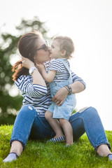 Portrait of a beautiful young woman with a small child in park