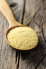 Raw couscous in a wooden spoon