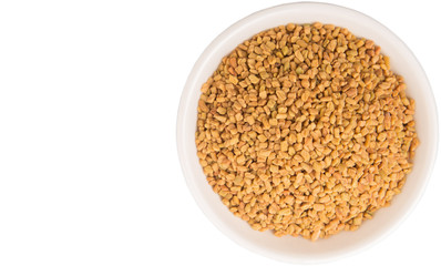 Fenugreek seeds in white bowl over white background