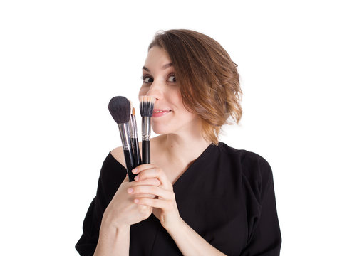 Smiling woman makeup artist with brushes on white background isolated