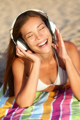 Woman listening to music with headphones at beach