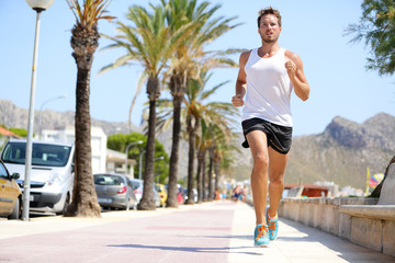 Fit male runner running outside on boardwalk