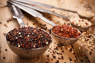 Mix of quinoa grain in metal measuring spoons