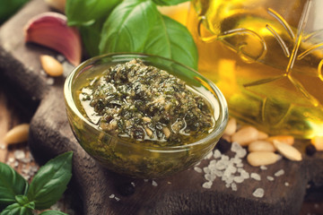 Homemade pesto on rustic wooden cutting board. 