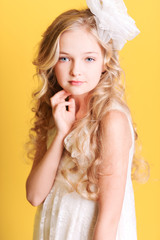 Cute kid girl 10 years old posing over yellow background