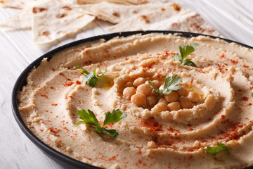 Traditional hummus with parsley on the plate close-up 