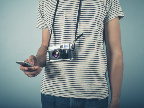 Hipster with vintage camera and smartphone