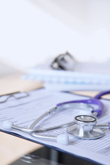 Purple stethoscope on the glass desk