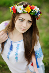 girl with freckles on her face in a Ukrainian shirt and floral b