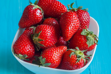 Plate of strawberries on a wooden table.