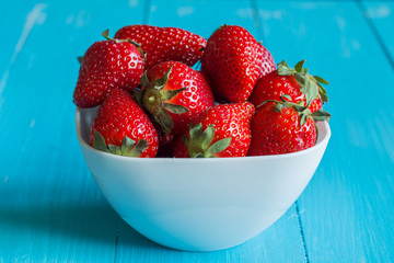Plate of strawberries on a wooden table.