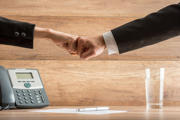 Fist to Fist of Business People Over the Table