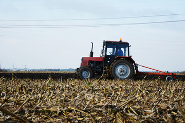 Tractor in the field in the middle of tillage