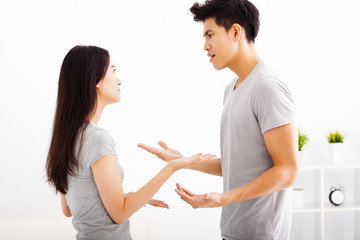 Angry young couple arguing in living room