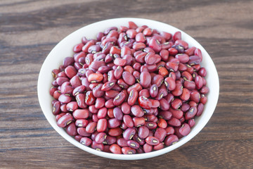 Adzuki bean or red bean in white bowl on wood background