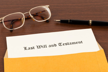 Last will on cream color paper with glasses and pen in envelope,