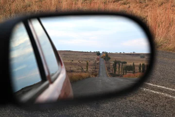 Zelfklevend Fotobehang South African landscape in a car mirror. © Therina Groenewald