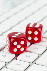 Three red dice on keyboard, online casino concept