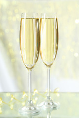 Glasses of champagne on lights background