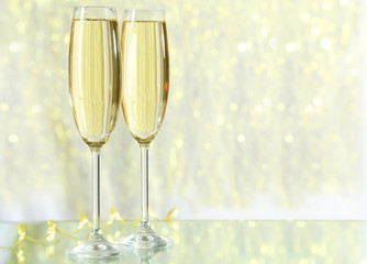 Glasses of champagne on lights background