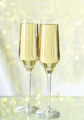 Glasses of champagne on lights background