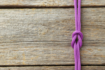 Purple rope on grey wooden background