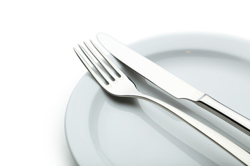 Fork, knife and plate on white background