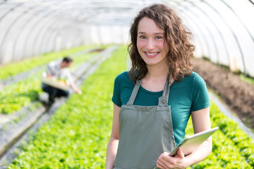 Portrait of an attractive farmer in a greenhouse using tablet