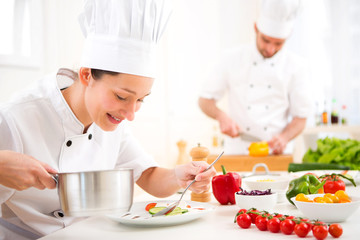 Young attractive professional chef cooking in his kitchen