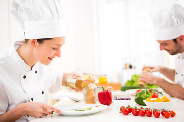 Young attractive professional chef cooking in his kitchen