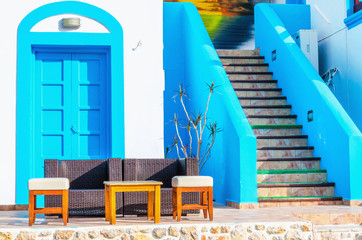 Sofa in front of Greek house painted with blue