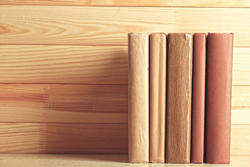 Books on shelf, close-up, on wooden background