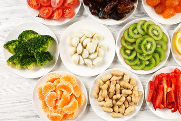 Different products on saucers on wooden table, top view
