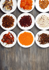 Different products on saucers on wooden background