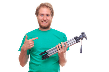 Bearded young man holding tripod