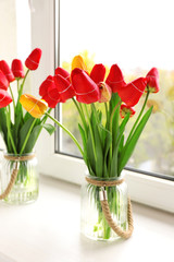 Bouquet of fresh tulips on windowsill background