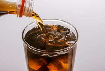 Refreshing Brown Soda with Ice on a background