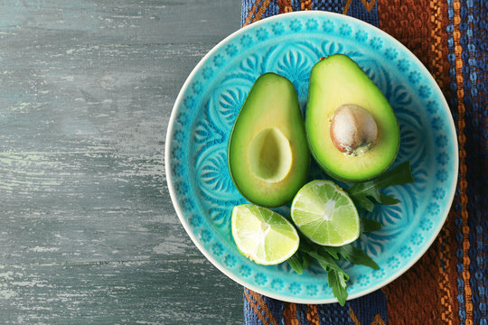 Sliced avocado and lemon lime on wooden background