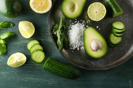 Sliced avocado, cucumber/ pepper and lemon lime on wooden background