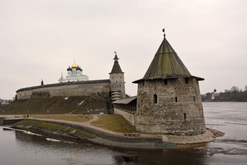 Fototapeta na wymiar Stone tower and Pskov Kremlin fortress wall at the confluence of two rivers