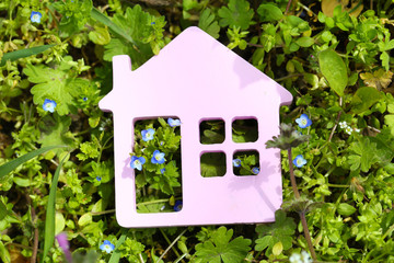 Toy house on grass background