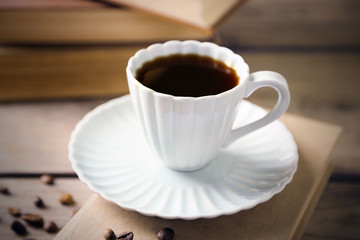 Still life with cup of coffee and books, on wooden table