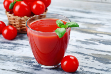 Glass of tomato juice with vegetables on wooden background