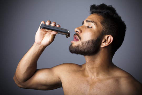 Hombre con barba apurando petaca