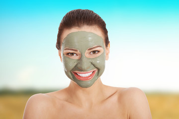 Beautiful woman with clay facial mask.