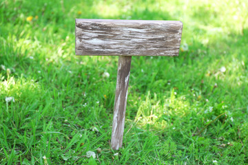 Wooden signboard over grass, outdoors