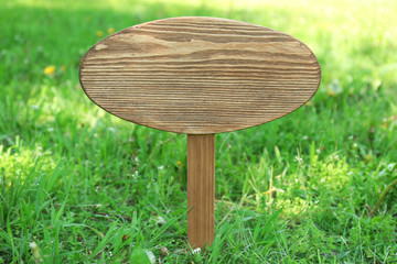 Wooden signboard over grass, outdoors