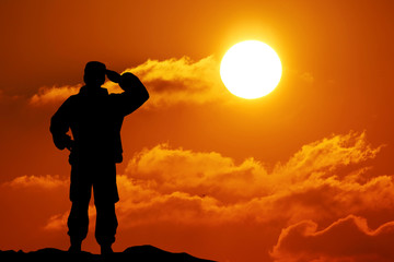 Fototapeta na wymiar Silhouette of soldier with rifle against a sunset