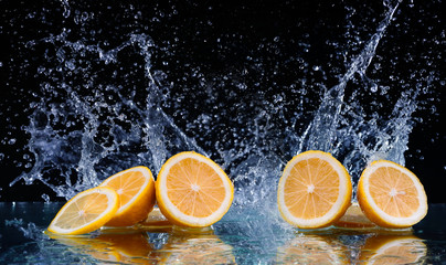 Sliced lemon in the water on black background