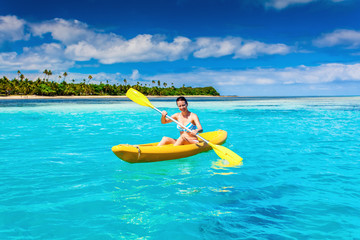 Woman Kayaking in the Ocean on Vacation in tropical island